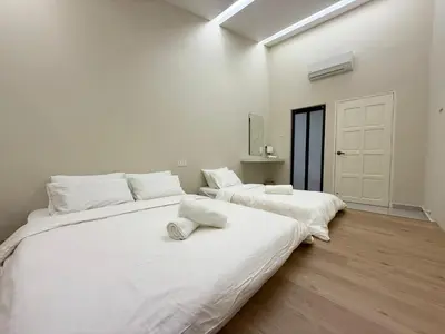 two beds in a room with white walls at Taiping Corner Homestay in Taiping