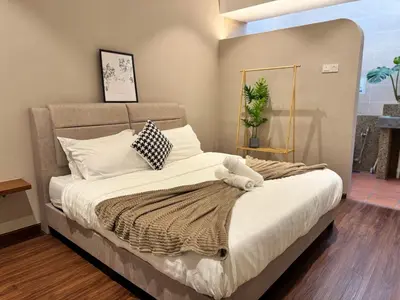 a bedroom with a large bed with white sheets and pillows at Ruyu 44 TownVilla 5R4B 18pax Bbq KTV Pool Table in Ipoh