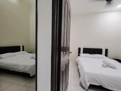 a bedroom with two beds with white sheets and a mirror at EcoPutra Stay in Ipoh