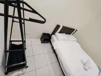 a bed with white pillows and a ladder in a room at EcoPutra Stay in Ipoh