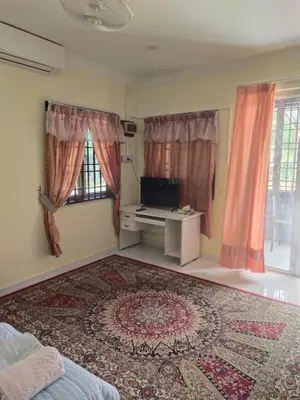 a living room with a tv and two windows at Teratak Desa Cemerlang 3 in Kuala Kangsar