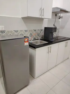 a white kitchen with a sink and a refrigerator at CK Homestay in Ipoh