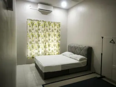 a small bedroom with a bed and a curtain at damai homestay - feel like a home in Sitiawan