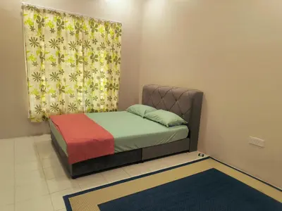 a small bedroom with a bed with a curtain at damai homestay - feel like a home in Sitiawan