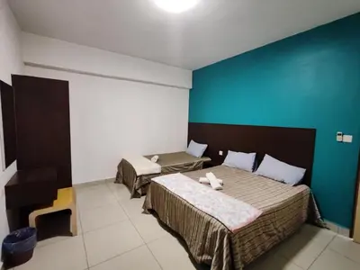 a bedroom with two beds and a blue wall at KIMNA HOME at MARINA HEIGHT in Lumut