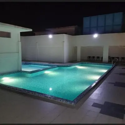 a large swimming pool with green water at night at D'Royale NH Homestay Kompleks Mutiara Gua Musang in Gua Musang