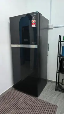 a black refrigerator sitting in the corner of a room at Azura Homestay Seri Iskandar in Seri Iskandar