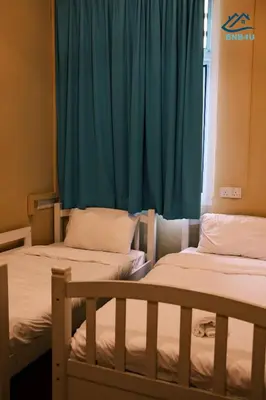 two beds in a room with a blue curtain at City-Center Heritage Getaway for 12 Pax in George Town