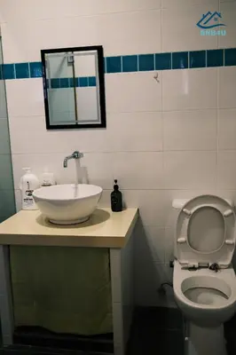 a bathroom with a sink and a toilet and a mirror at City-Center Heritage Getaway for 12 Pax in George Town