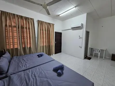 a bedroom with a bed and a door with curtains at Pera House Hostel in Ipoh
