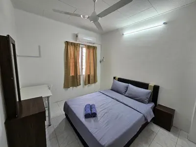 a bedroom with a bed with blue shoes on it at Pera House Hostel in Ipoh