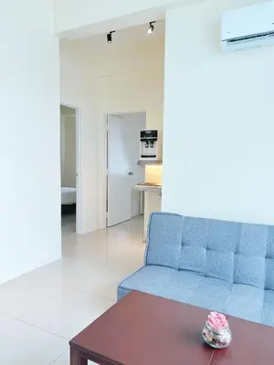 a living room with a blue couch and a table at Cozy 2-Bedroom Balcony Suite with Living Room in Nibung Tebal