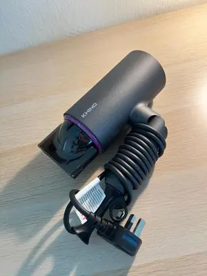 a black flashlight on a table with a remote control at Cozy 2-Bedroom Balcony Suite with Living Room in Nibung Tebal