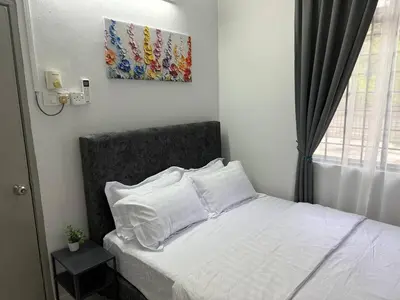 a bed with white sheets and pillows in a bedroom at Wareesha Homestay, Corner Lot With Netflix in Padang Serai