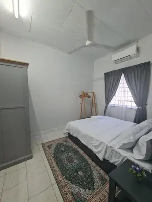 a bedroom with a bed and a window and a rug at Wareesha Homestay, Corner Lot With Netflix in Padang Serai