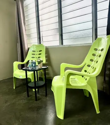 two green chairs and a table in a room at Little Stay Inn in Taiping