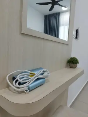 a bathroom counter with a hair dryer and a mirror at Studio Unit Marc Residence in Bukit Mertajam