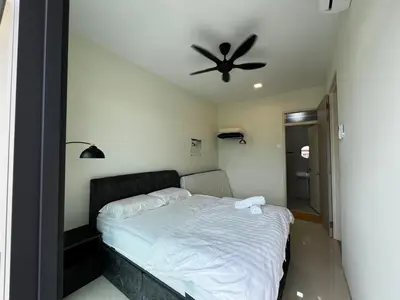 a bedroom with a bed with a ceiling fan at AP Homestay in Sekincan