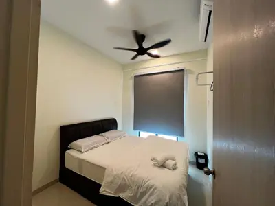 a bedroom with a bed with a ceiling fan at AP Homestay in Sekincan