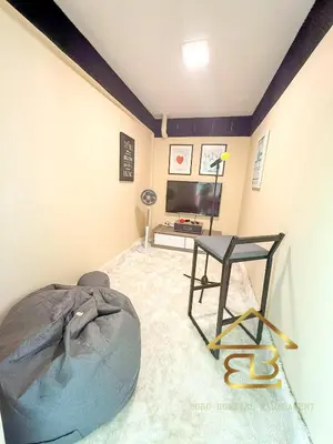 a room with a bed and a table and a television at Ipoh City Centre Penthouse 12-15 Pax KTV BBQ in Ipoh