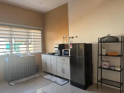 a kitchen with a stainless steel refrigerator in a room at Harees Homestay in Kuala Lipis