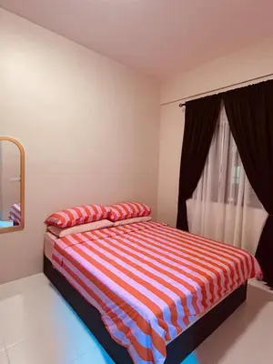 a bedroom with a bed with red and blue stripes at WiU Cottage, Seri Iskandar in Seri Iskandar