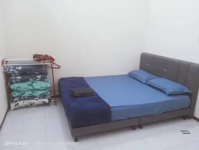 a bedroom with a bed with blue sheets and a closet at Homestay Bajet EM1 Pantai Remis PK in Pantai Remis