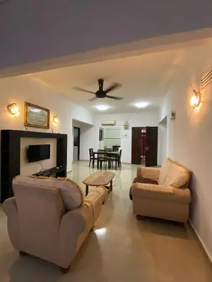 a living room with two couches and a tv at Risma Homestay in Batu Ferringhi