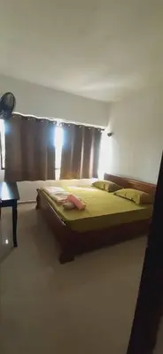 a bedroom with a bed and a window with curtains at Risma Homestay in Batu Ferringhi