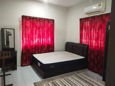 a bedroom with a bed and red curtains at Teratak Desa Cemerlang 1
