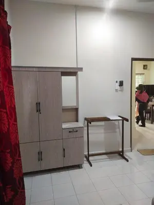 a room with a wooden cabinet and a table at Teratak Desa Cemerlang 1