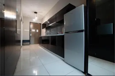 a kitchen with a white refrigerator and black cabinets at Maritime suite Karpal sign sea view in George Town