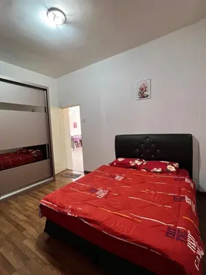 a bedroom with a bed with a red comforter at Highland Breze Homestay in Tanah Rata