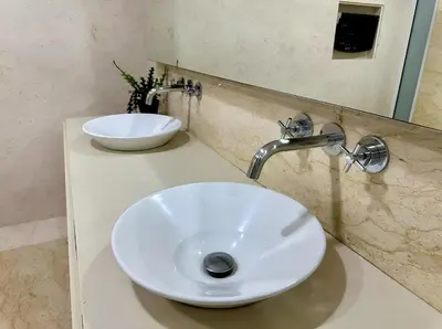 a bathroom with a white sink and a mirror at Marina Chic l Stylish 2BR Retreat l Straits Quay in Tanjung Bungah