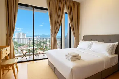 a bedroom with a bed and a balcony with a table at \u3010Lux\u3011HighFloor wi SunSet | Infinity Pool | KTV 207 in George Town