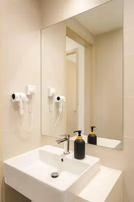 a bathroom with a white sink and a mirror at \u3010Lux\u3011HighFloor wi SunSet | Infinity Pool | KTV 207 in George Town
