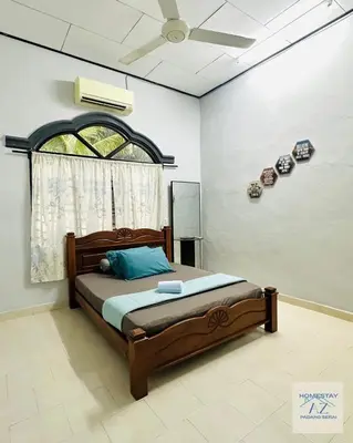a bedroom with a bed and a ceiling fan at Homestay AZ Padang Serai in Padang Serai