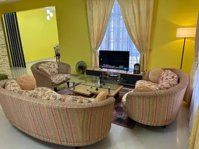 a living room with two chairs and a tv at GS Homestay Whole Villa in Gertak Sanggul