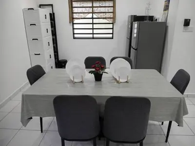 a dining room with a table with chairs and a refrigerator at Balqis LN Homestay in Taiping