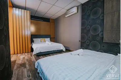 a bedroom with two beds and a wall with at Luxe Retreat Homestay by Verve in Ipoh