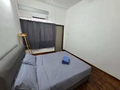 a small bedroom with a bed with a blue pillow on it at Ipoh Stadium Hostel in Ipoh