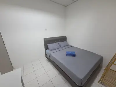 a bed with a blue pillow on it in a room at Ipoh Stadium Hostel in Ipoh