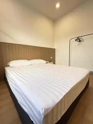 a large white bed in a room with a lamp at relaxing home in Bukit Mertajam in Bukit Mertajam