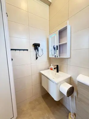 a bathroom with a white sink and a mirror at relaxing home in Bukit Mertajam in Bukit Mertajam