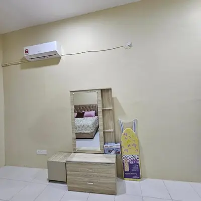 a mirror in a room with a bed and a skateboard at Residensi Lourve Homestay Sungai Petani in Sungai Petani