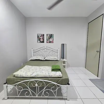 a bedroom with a bed in a white room at Residensi Lourve Homestay Sungai Petani in Sungai Petani