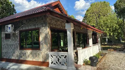 a small house with a large window at D'Kebun Lenggong Perak Chalet in Gua Sai