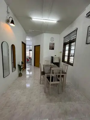 a dining room with a table and chairs at Santai DPermai Homestay in Selama
