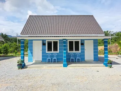 a blue house with chairs in front of it at Teratak Sumayyah 2 - For Islam only - Pondok Lenggong in Kampong Banggol Belimbing