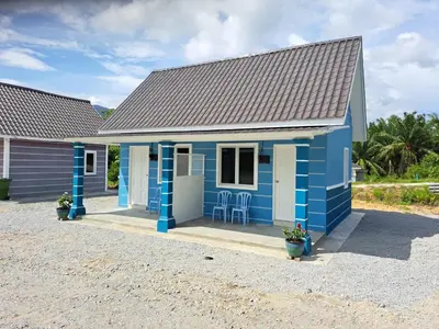 a blue house with chairs in front of it at Teratak Sumayyah 2 - For Islam only - Pondok Lenggong in Kampong Banggol Belimbing